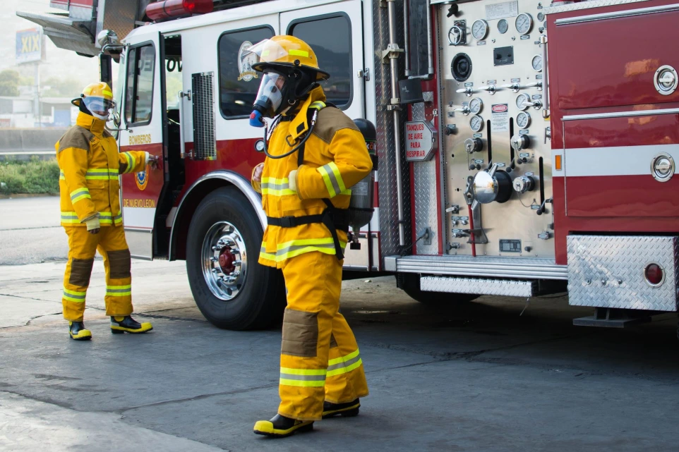 Kit completo de bombero brigadista bajando de camión de bomberos